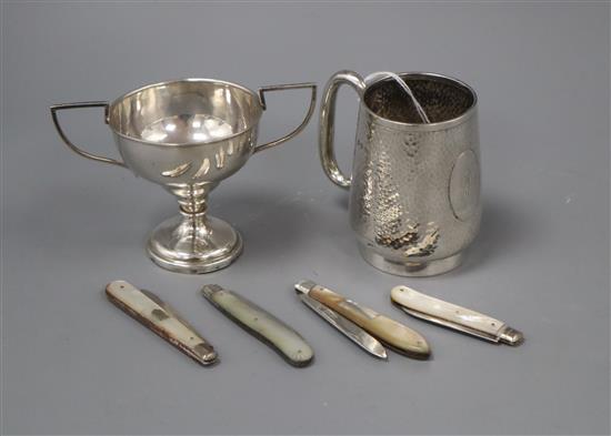 A George V silver christening cup, a white metal small trophy cup and four silver and mother of pearl fruit knives.